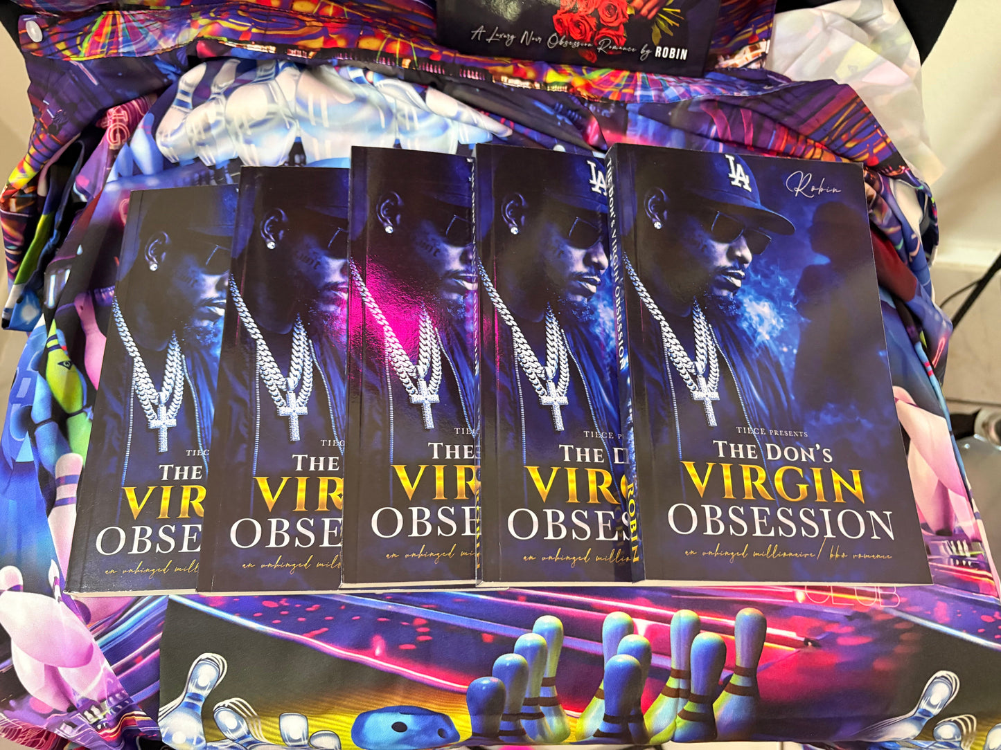 Booklets titled 'The Don's Virgin Obsession' displayed on a colorful background